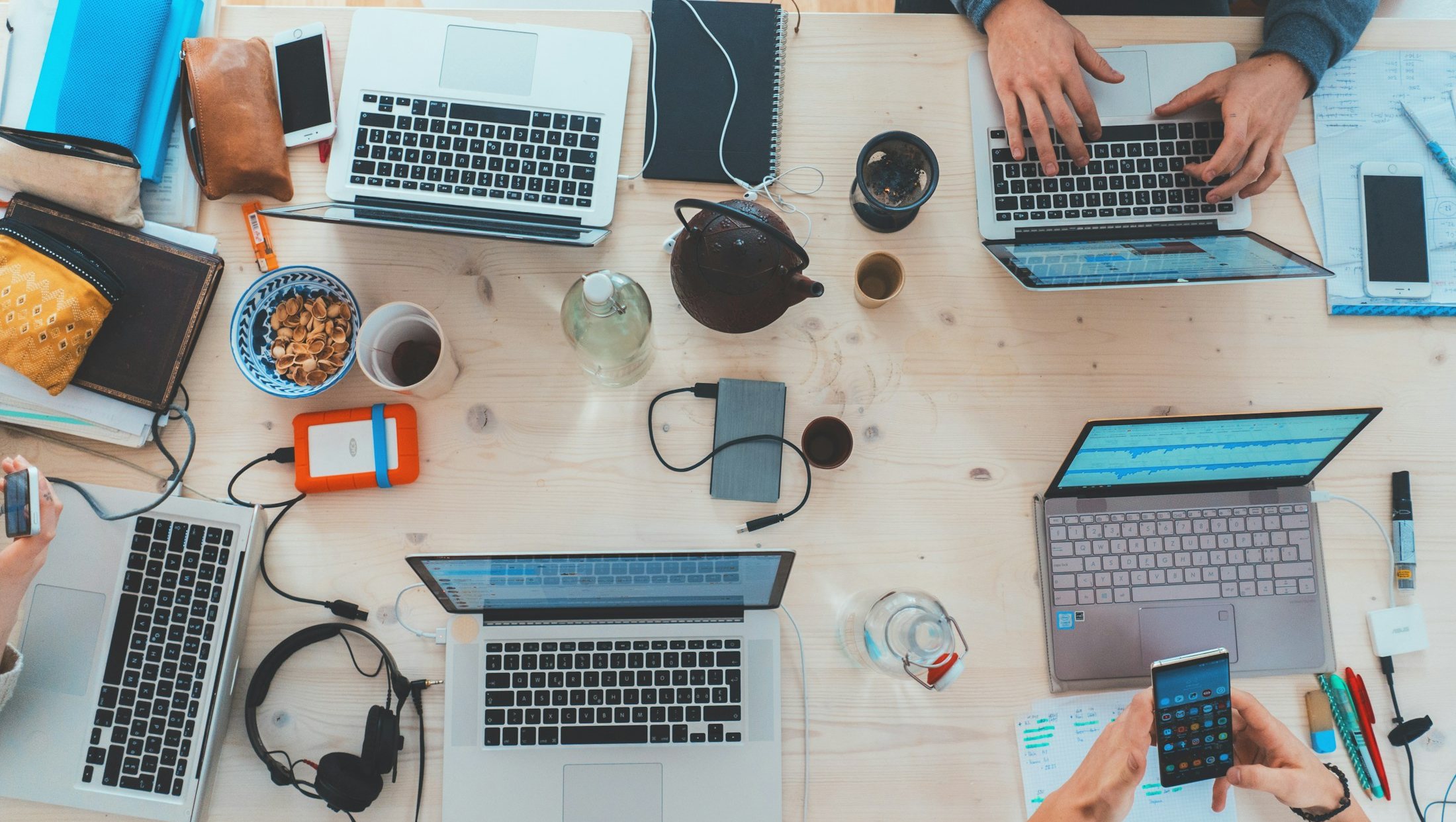 Colleagues working at laptops around a shared desk